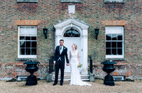 Bride and groom standing outside Swarling manor image by Nick Beal Wedding photographer in kent