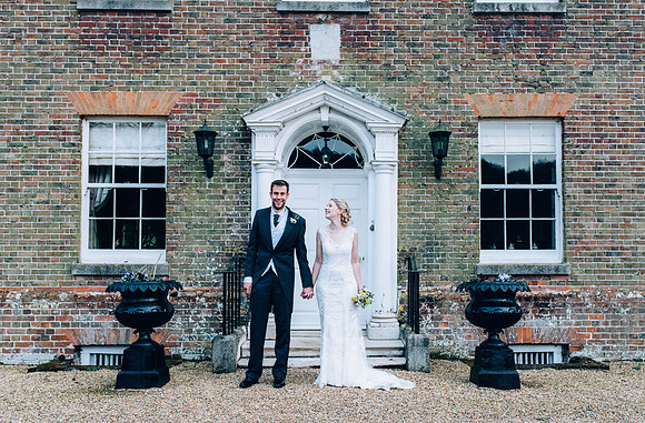 Bride and groom standing outside Swarling manor image by Nick Beal Wedding photographer in kent